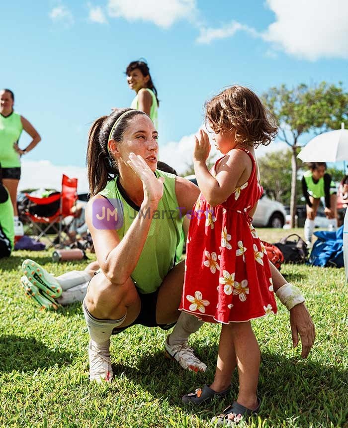 Woman high fiving a little girl at a sporting event